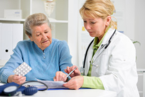 Doctor showing a medication to an older patient