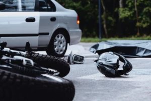 motorcycle and motorcycle helmet on the ground after an accident with a car