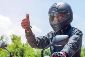man wearing helmet with thumb pointing up