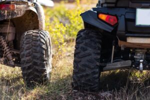 close up of rear end of off highway vehicles parked in grass