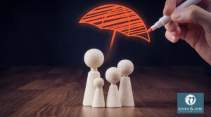 Family life and property insurance concept. Wooden figurines representing family and hand drawing umbrella, symbol of insurance.